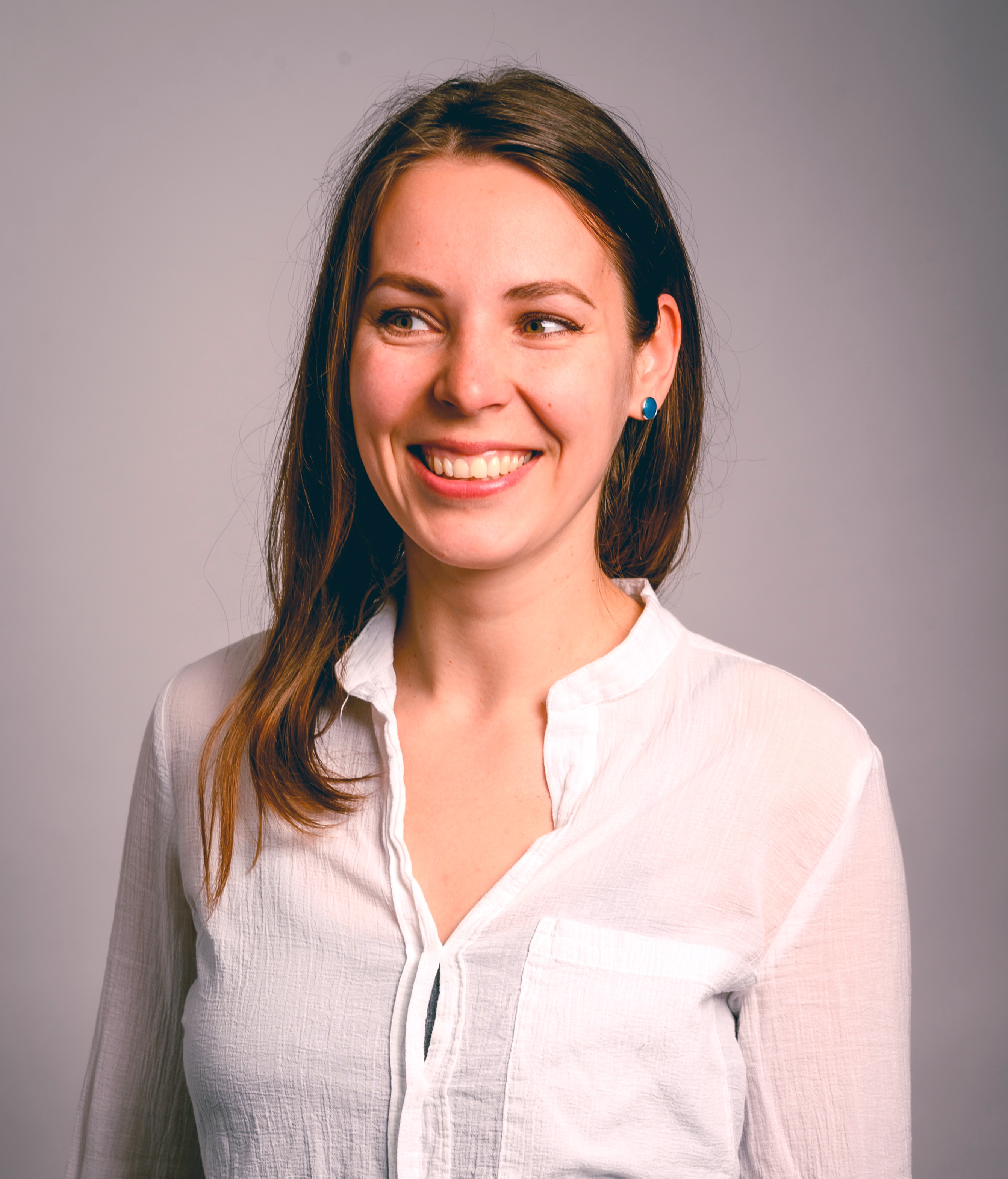 An image of a smiling woman in white blouse and long hair - Kateryna Melanych